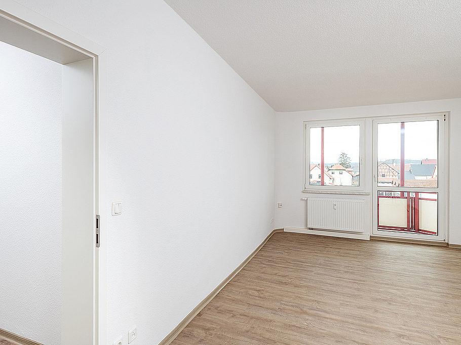 Lichtdurchflutetes Wohnzimmer in Stadtilm mit Balkon, stilvollem Bodenbelag in Holzoptik und eleganten weißen Türen